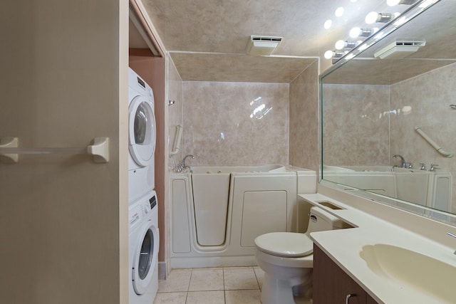 full bath with a garden tub, tile patterned floors, vanity, and stacked washer / drying machine