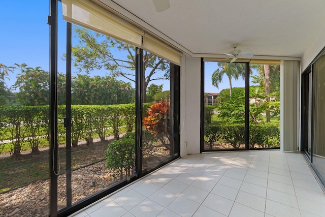 unfurnished sunroom featuring a ceiling fan