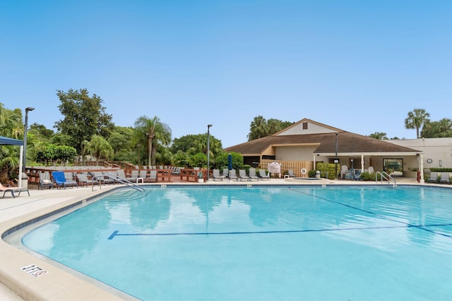 community pool with a patio and fence