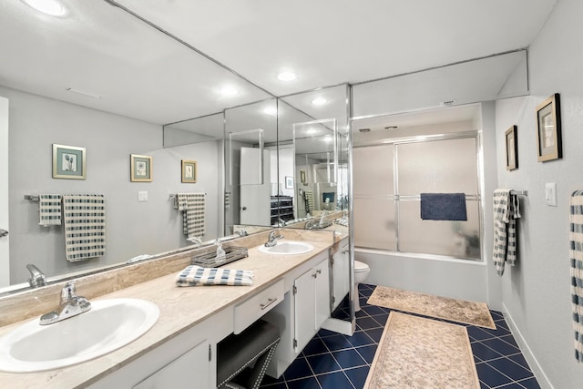 full bath featuring shower / bath combination with glass door, a sink, toilet, and tile patterned floors