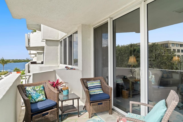 balcony with a water view and a sunroom