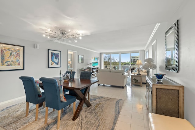 dining space featuring a notable chandelier, baseboards, crown molding, and light tile patterned flooring