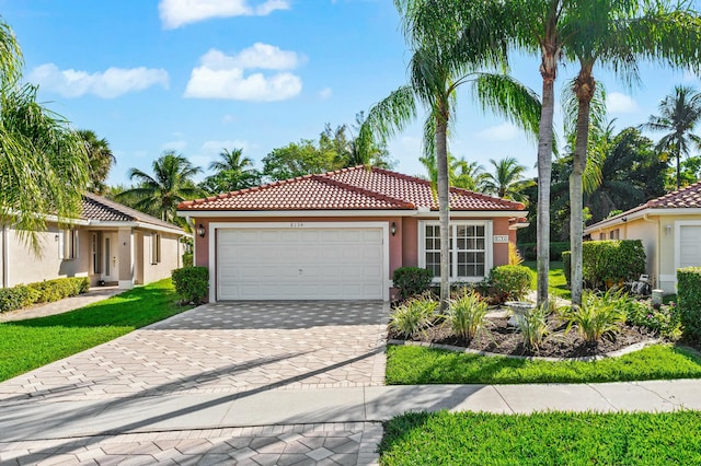 mediterranean / spanish-style house with an attached garage, a tile roof, and stucco siding