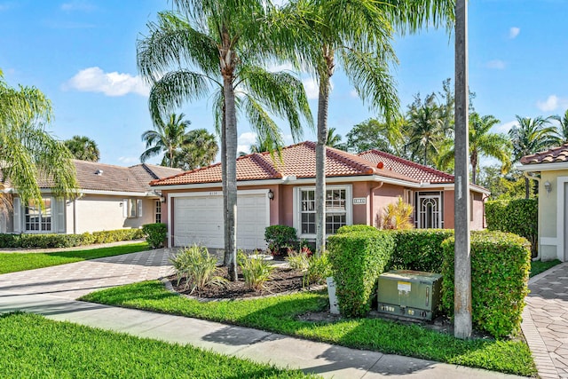 view of front of property with a garage, a tile roof, decorative driveway, and stucco siding