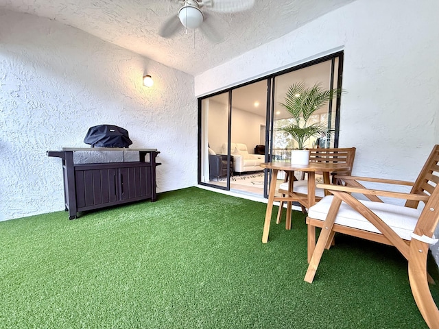 interior space with ceiling fan, carpet flooring, and a textured ceiling