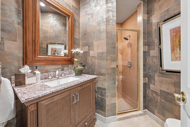 bathroom featuring tile patterned floors, a shower with shower door, tile walls, and vanity