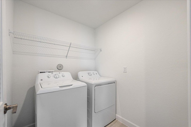 laundry room with laundry area, baseboards, and washer and clothes dryer