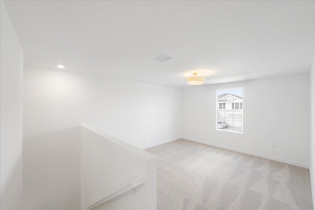 empty room with recessed lighting, visible vents, baseboards, and light colored carpet