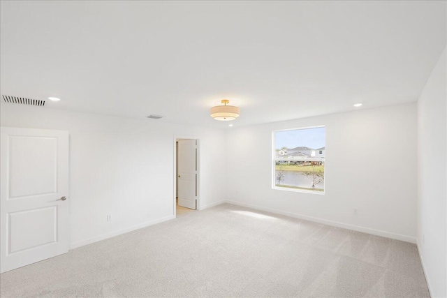 unfurnished room featuring recessed lighting, light carpet, visible vents, and baseboards