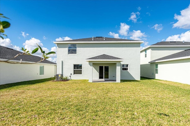 rear view of property with central AC, a lawn, and stucco siding