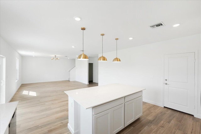 kitchen featuring visible vents, open floor plan, light countertops, white cabinetry, and pendant lighting