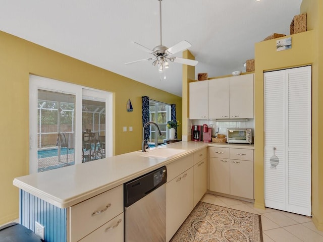 kitchen featuring kitchen peninsula, sink, a healthy amount of sunlight, dishwasher, and light tile patterned flooring