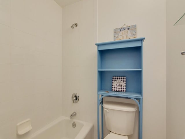 bathroom with toilet and tiled shower / bath