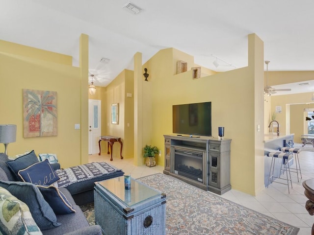 living room with ceiling fan, light tile patterned floors, sink, and vaulted ceiling