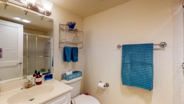 bathroom featuring vanity, toilet, and walk in shower