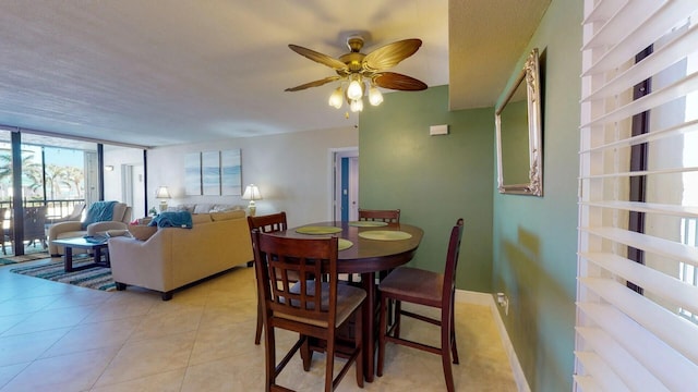 tiled dining room with ceiling fan and expansive windows