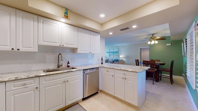 kitchen featuring white cabinetry, kitchen peninsula, sink, stainless steel dishwasher, and light stone counters