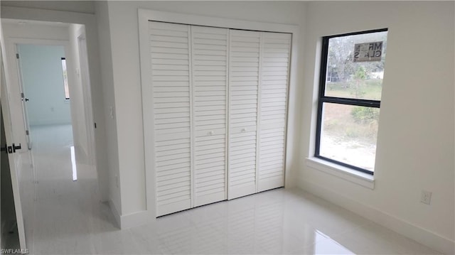 unfurnished bedroom featuring light tile patterned floors and a closet