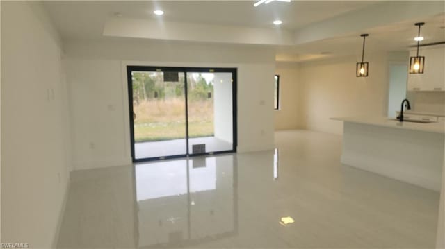 spare room featuring a raised ceiling and sink