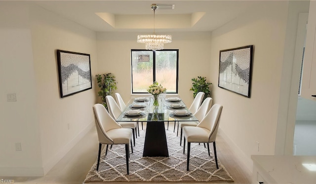 dining space featuring wood-type flooring, a chandelier, and a tray ceiling