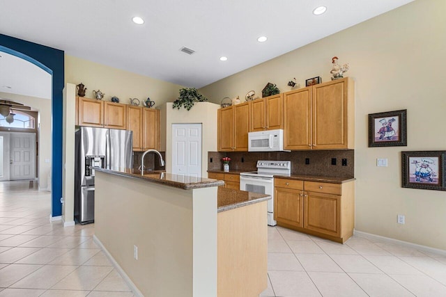 7357 Marbella Echo Dr, Delray Beach, FL 33446 - kitchen featuring white appliances, a center island with sink, light tile patterned flooring, and decorative backsplash