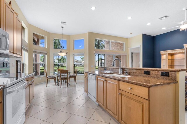 7357 Marbella Echo Dr, Delray Beach, FL 33446 - kitchen with white appliances, decorative light fixtures, light tile patterned floors, sink, and dark stone countertops