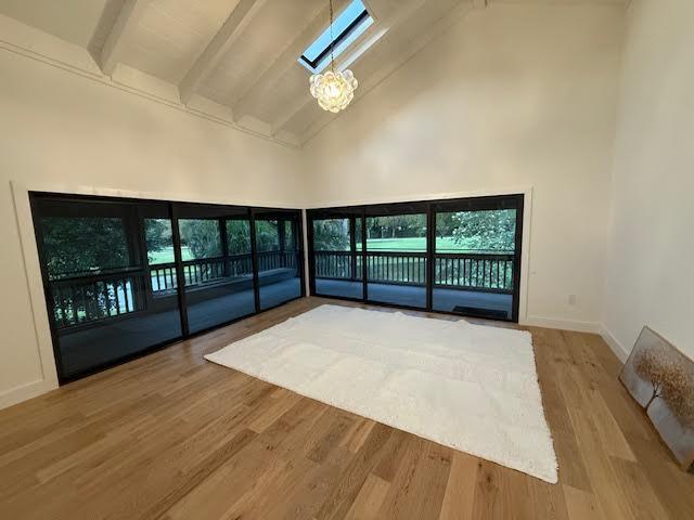 unfurnished sunroom featuring a notable chandelier and lofted ceiling with beams