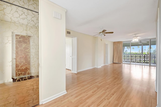 unfurnished room with a fireplace, light hardwood / wood-style flooring, and expansive windows