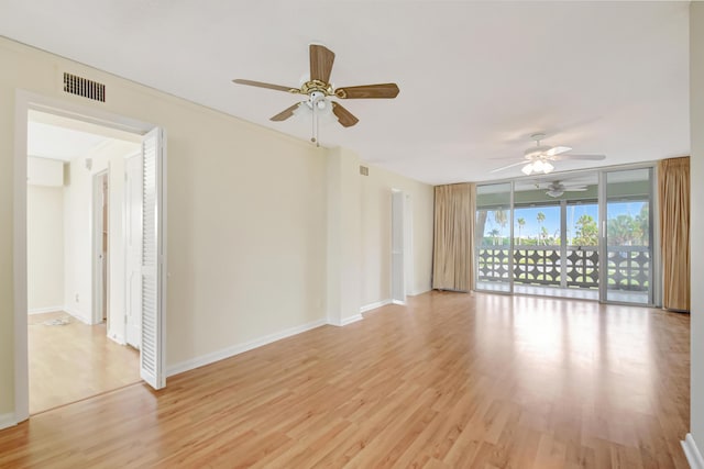 unfurnished room featuring light hardwood / wood-style floors, ceiling fan, and floor to ceiling windows