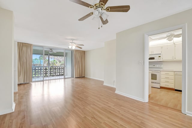 unfurnished living room with light wood-type flooring and a wall of windows