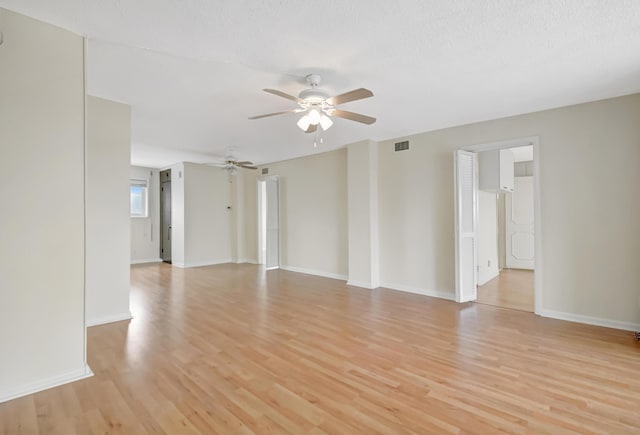 unfurnished room featuring ceiling fan, light hardwood / wood-style floors, and a textured ceiling