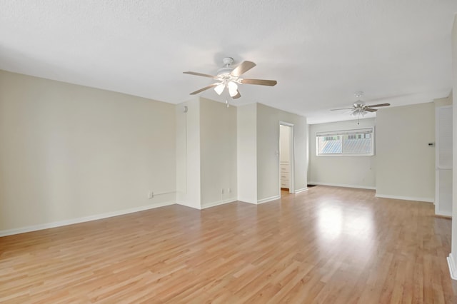 spare room with a textured ceiling, ceiling fan, and light hardwood / wood-style flooring