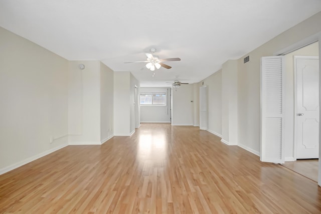 empty room with ceiling fan and light hardwood / wood-style flooring