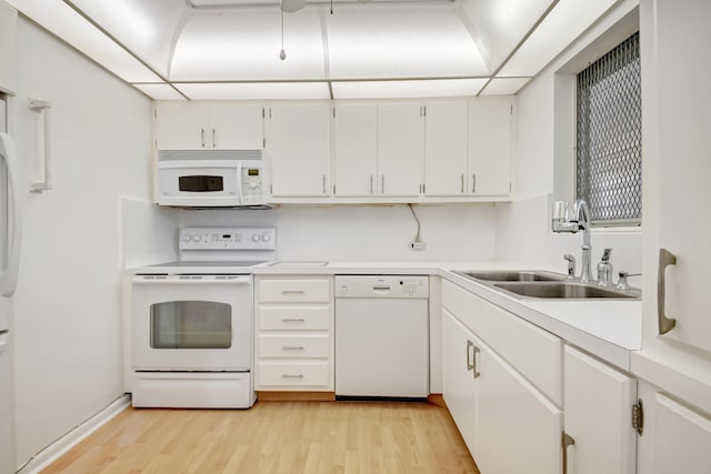 kitchen with sink, white appliances, white cabinets, and light hardwood / wood-style floors