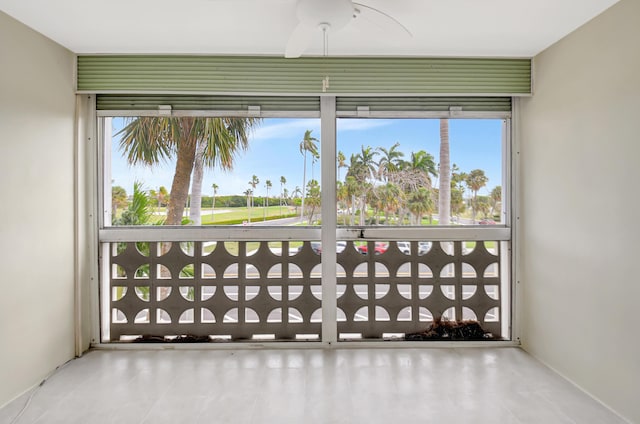 unfurnished sunroom featuring ceiling fan