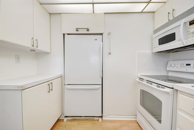 kitchen featuring white cabinetry, white appliances, and light hardwood / wood-style flooring