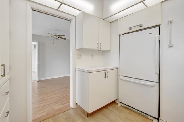 kitchen with white cabinetry, white fridge, light wood-type flooring, and ceiling fan