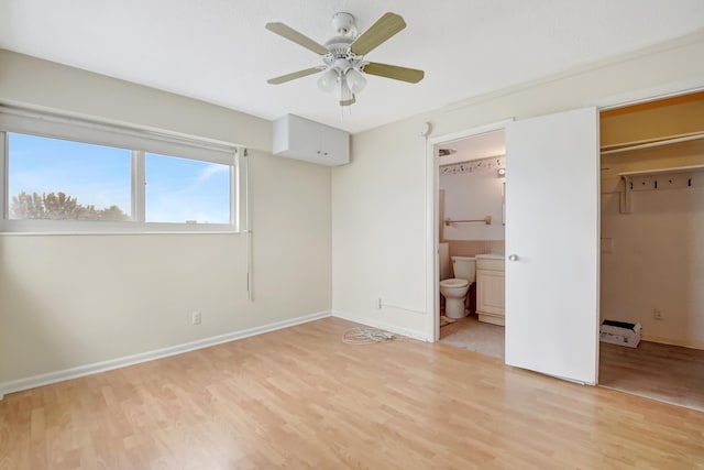 unfurnished bedroom featuring ceiling fan, light wood-type flooring, and connected bathroom