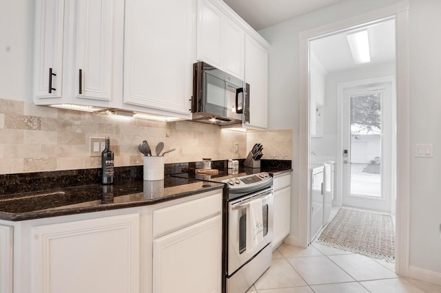 kitchen featuring washer and clothes dryer, dark stone counters, white cabinets, stainless steel range with electric cooktop, and backsplash