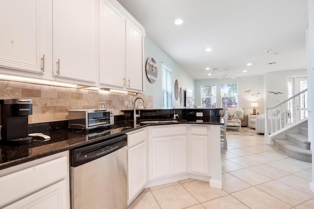 kitchen featuring a sink, dark stone countertops, white cabinets, and stainless steel dishwasher