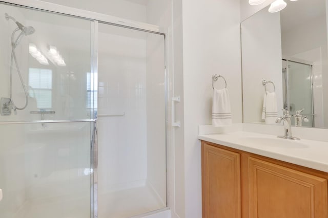 bathroom with a shower stall and vanity