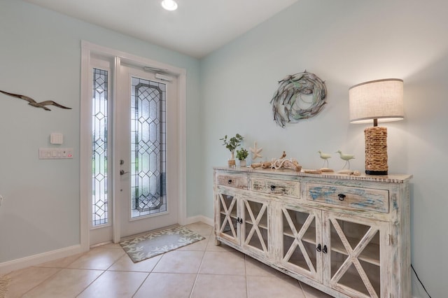 entrance foyer with light tile patterned floors, a wealth of natural light, and baseboards