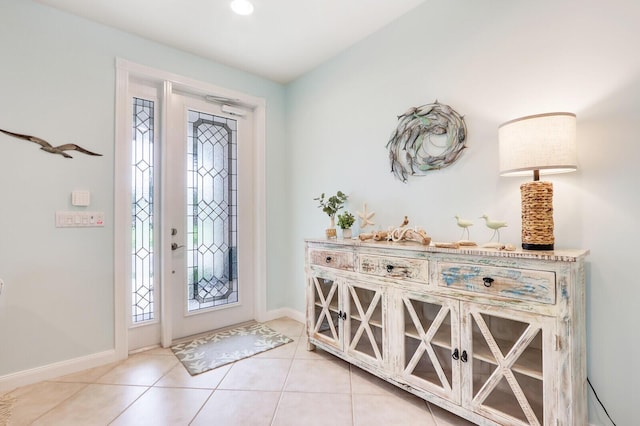 entrance foyer featuring baseboards and light tile patterned floors