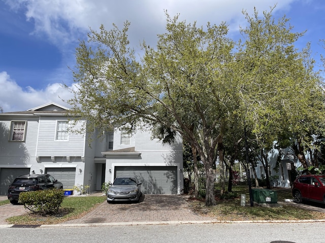 view of front of property with decorative driveway, stucco siding, and a garage