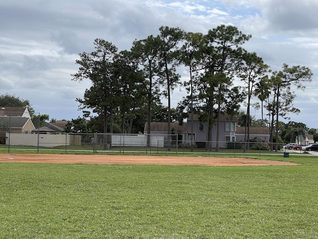 surrounding community featuring fence, concrete driveway, and a lawn
