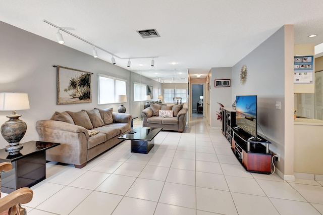 living area with rail lighting, visible vents, baseboards, and light tile patterned floors
