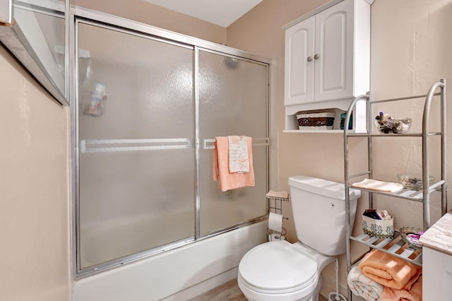 bathroom featuring toilet and enclosed tub / shower combo