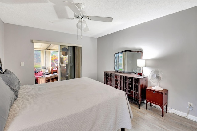 bedroom with a textured ceiling, ceiling fan, and light hardwood / wood-style flooring