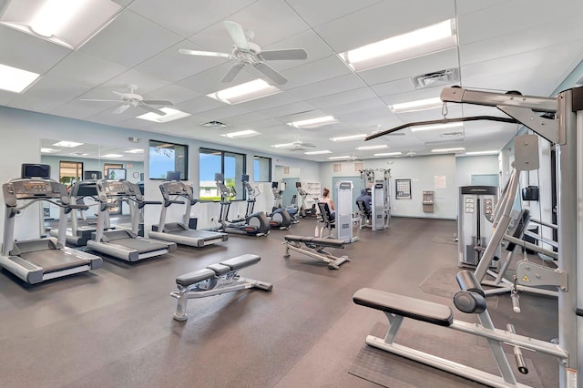 workout area with ceiling fan and a paneled ceiling