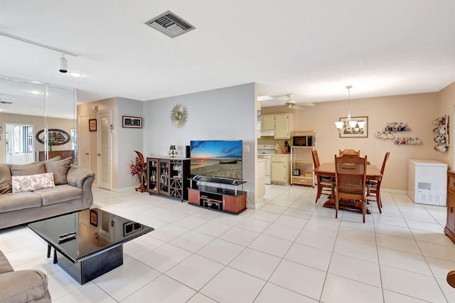 living room featuring ceiling fan with notable chandelier, light tile patterned floors, and rail lighting